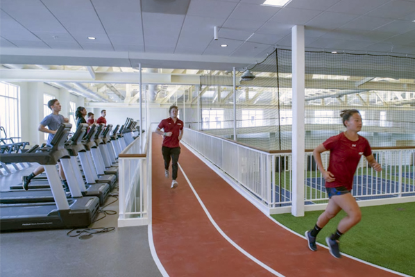 Students running along the track in the new Margot Connell Recreation Center as students on treadmills look on