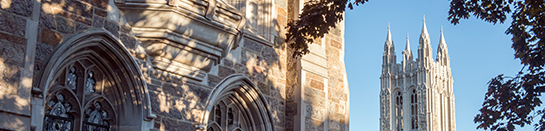 Gasson Hall with trees in forefront and against a blue sky background