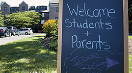 Chalk board displayed outside dorms with message of welcome to students and parents
